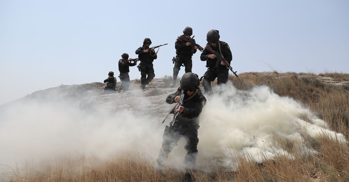 Chinese military researchers distilled OpenAI and Anthropic outputs to train defense AI Soldiers advancing through a field with smoke during a training exercise.