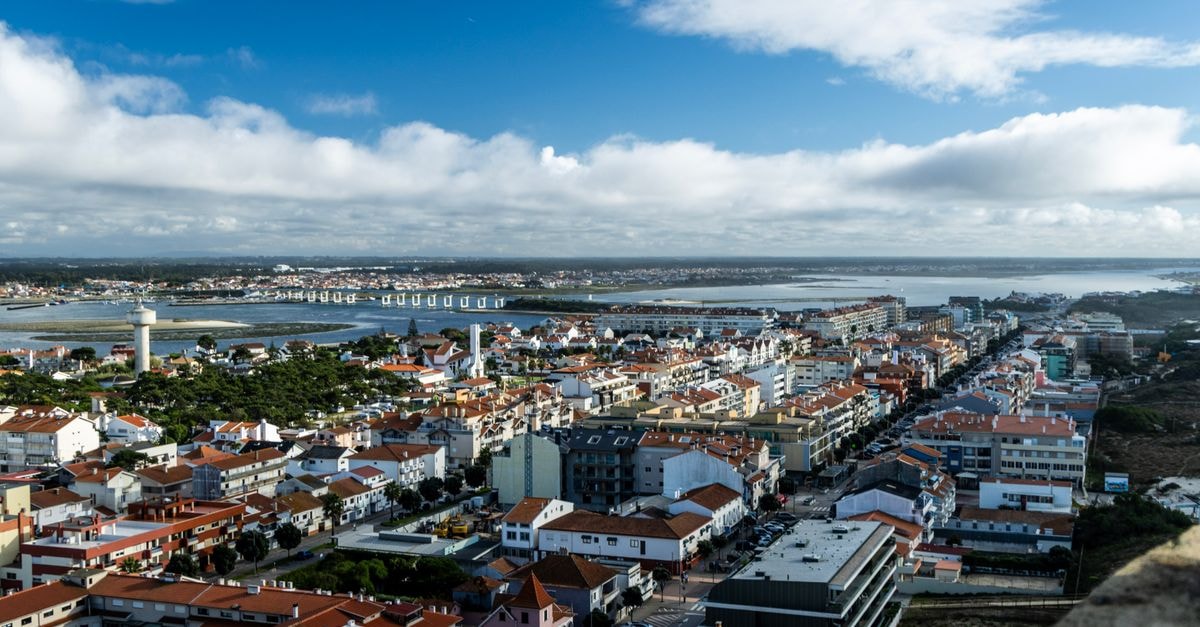 Pensão Areias in Vila Real: Classic Guesthouse Near the City Center A vibrant aerial view of a Portuguese coastal city with clear skies and scenic waterfront.