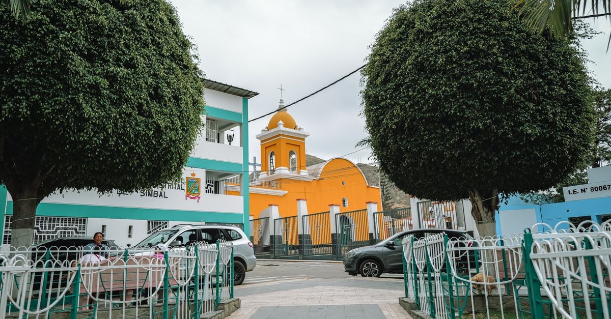 Jinotepe Travel Guide: A Slow-Paced Carazo Town Worth Discovering Colorful church and community scene in Simbal, Peru with vibrant architecture and lush greenery.