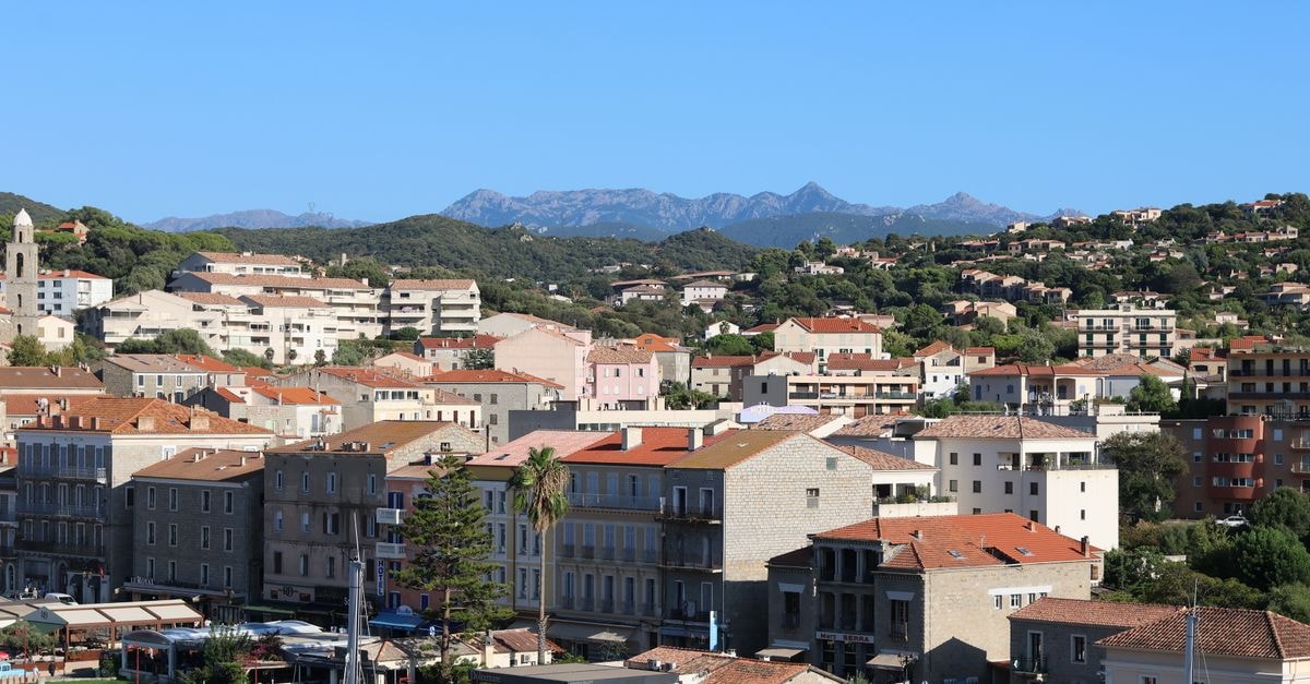 Hotel Atlantic in Gabès: A 1923 Landmark on Avenue Habib Bourguiba Picturesque view of a Mediterranean town with classic buildings and distant mountains under a blue sky.