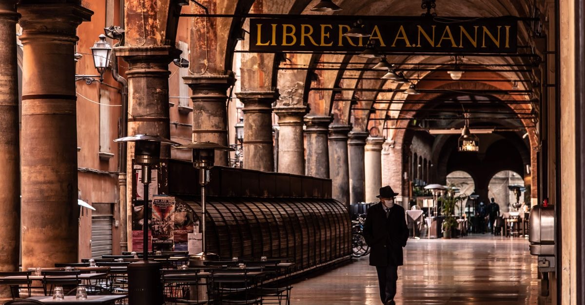 Hotel Touring, Bologna — Historic Centre Stay With a Rooftop Jacuzzi A man walks under the arches of Bologna's historic portico, Italy.