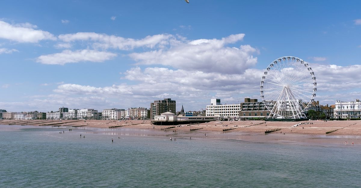 Brighton Travel Guide: Sea Air, Seafront Strolls, and Smart Day Choices Scenic view of Worthing's seafront with a prominent observation wheel under a blue sky.