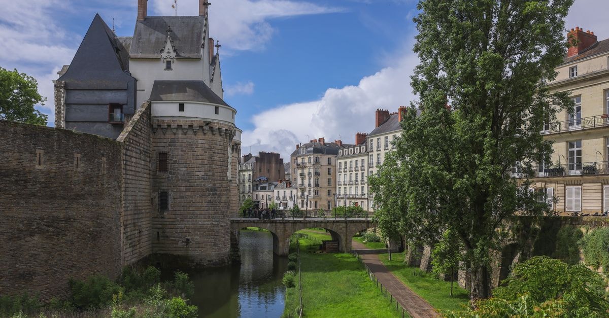Namur Travel Guide: A Quiet Citadel City at the River Confluence Scenic view of Château des Ducs de Bretagne with lush greenery and historic buildings in Nantes, France.