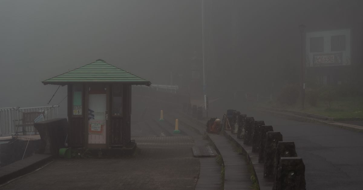 Hakone Pax Yoshino, Hakone — A Quiet Ryokan Address on Tōnosawa's滝通り A foggy morning scene in Hakone, Japan, highlighting tranquility with mist-covered roads.