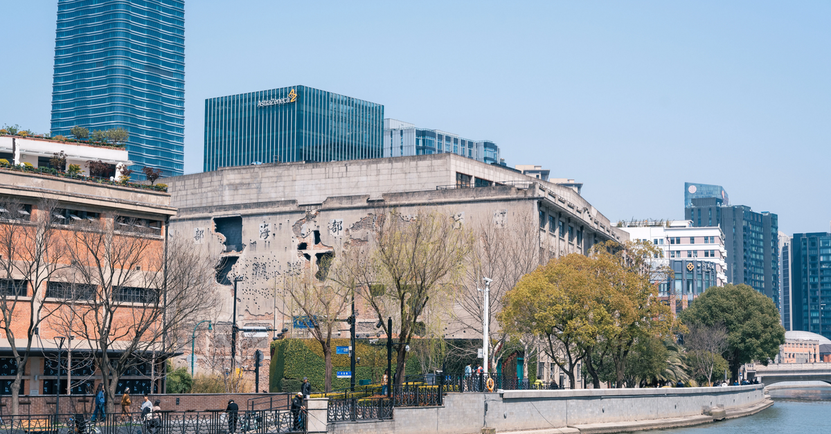 View of a city riverfront blending modern skyscrapers with historical architecture.