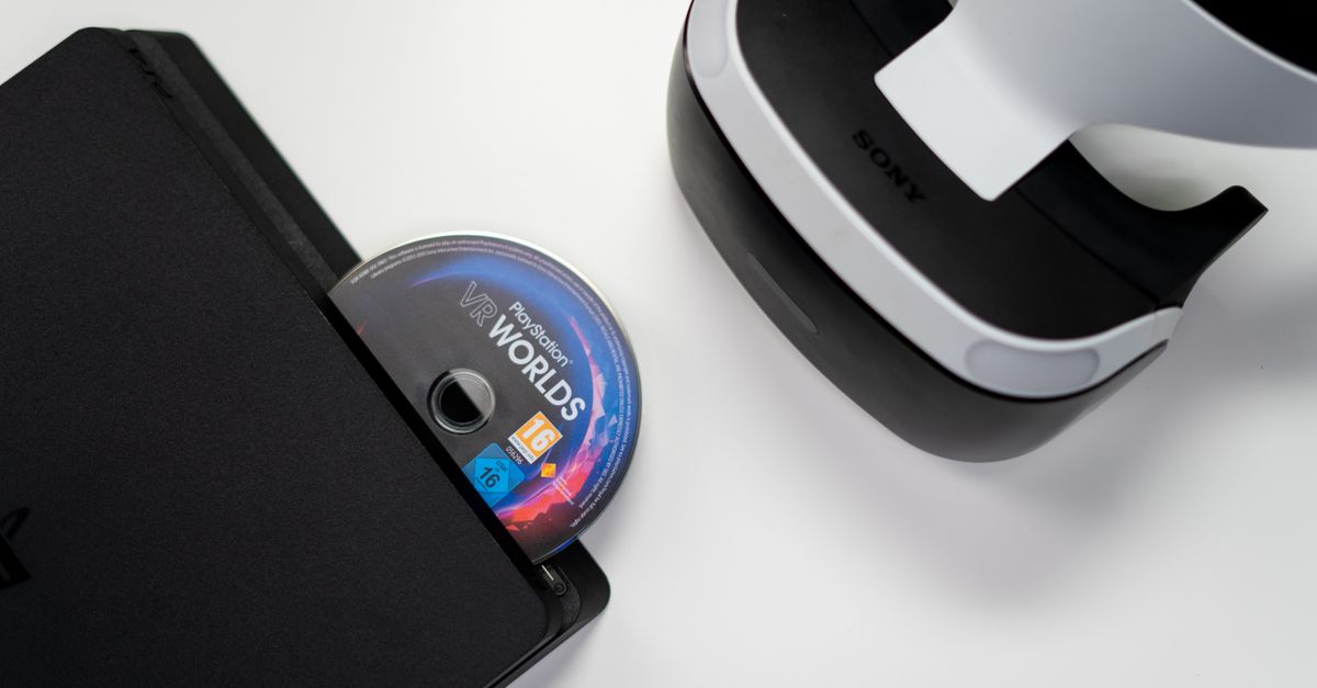 Ubisoft CEO says Sony's PlayStation disc exit won't disturb the industry Overhead view of PlayStation console, VR headset, and game disc on a white background.