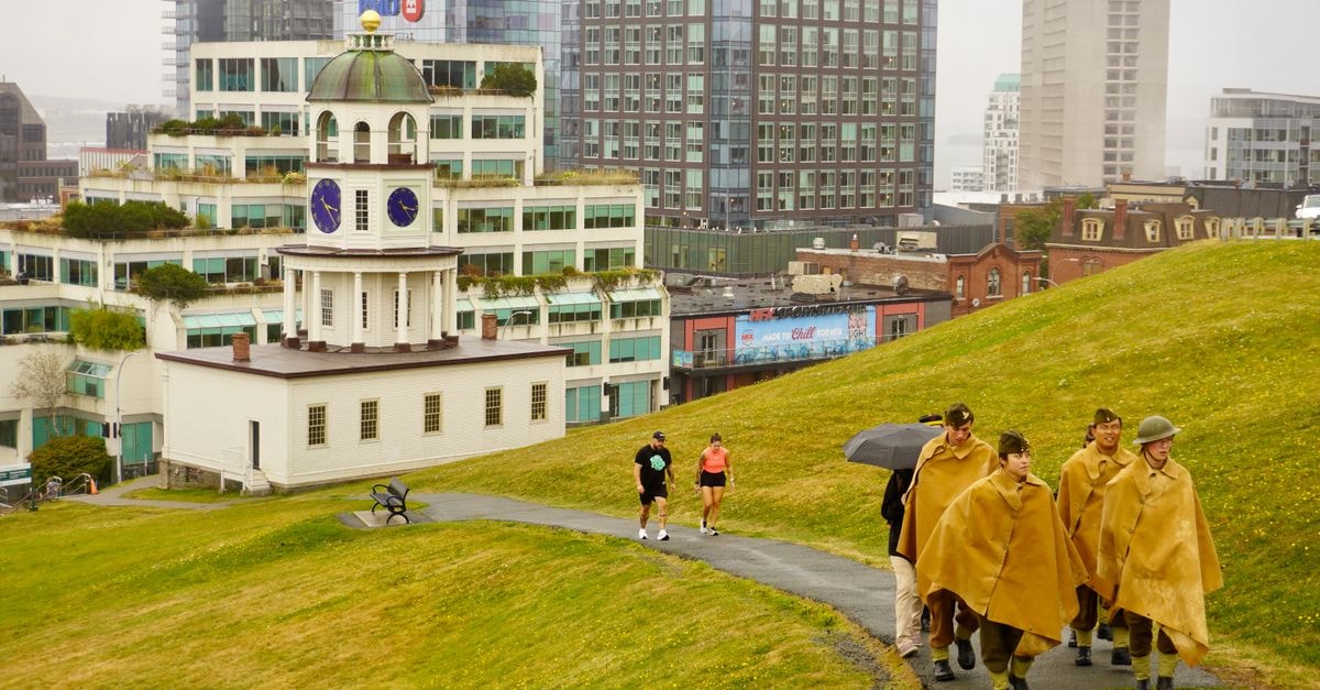Halifax Travel Guide: Harbour Walks and Atlantic Flavours Historic Halifax Clock Tower with people walking on Citadel Hill, cityscape backdrop, rainy day.