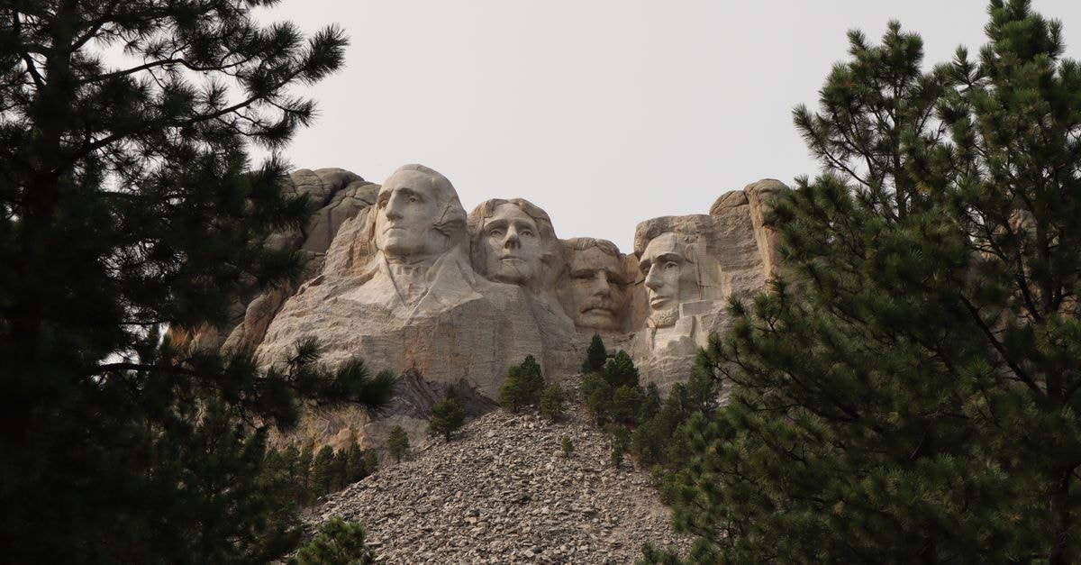 A Quiet Capital: Pierre, South Dakota Travel Guide Iconic Mount Rushmore National Memorial surrounded by trees on a clear summer day.