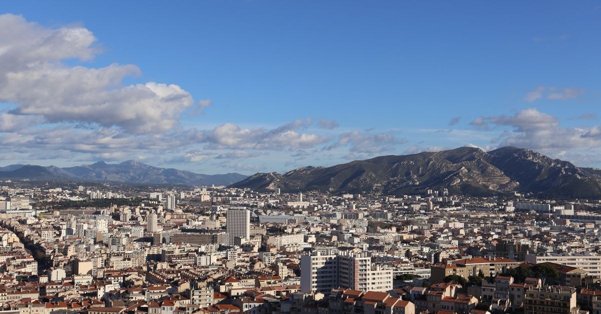 Hôtel Saint-Louis in Marseille: Noailles Boutique Hotel Near the Vieux-Port A stunning aerial view of the cityscape of Marseille, France, under a bright summer sky.