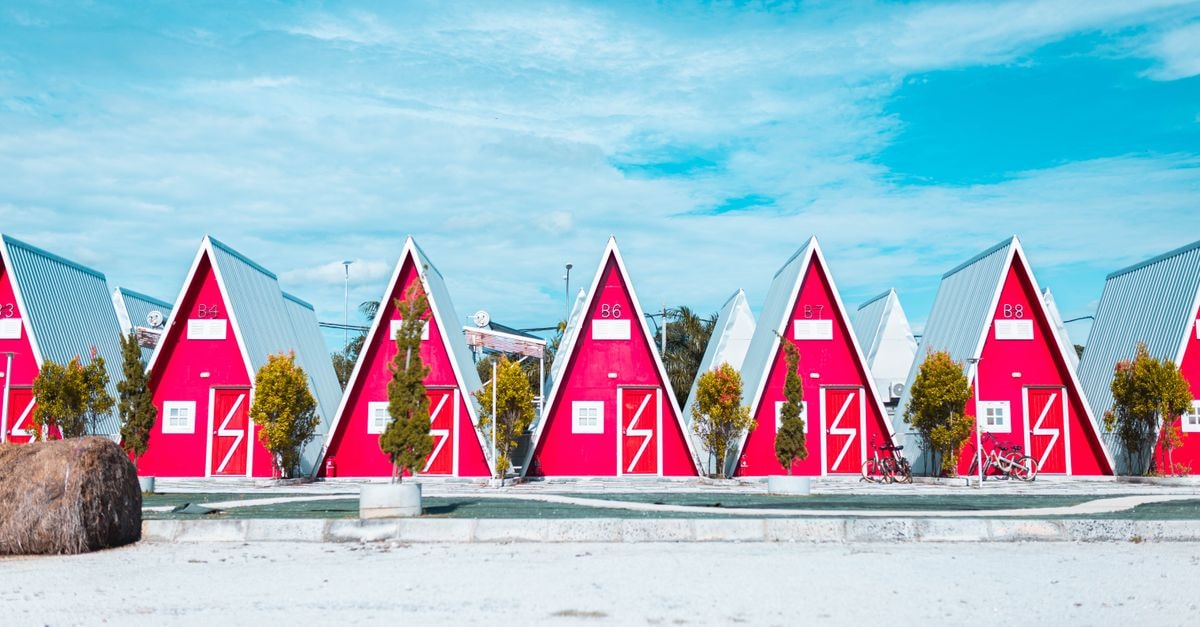 Kampung Baru Subang Travel Guide: A Quiet Selangor Neighbourhood Vibrant red and white triangular cabins against a bright blue sky, showcasing modern architecture.
