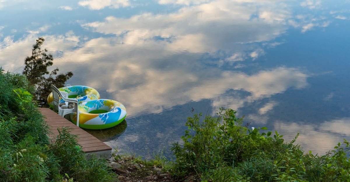 Family Hotel Ring in Montana: Lakeside Calm by Ogosta Reservoir Serene lakeside view with inflatable rings and scenic reflection.