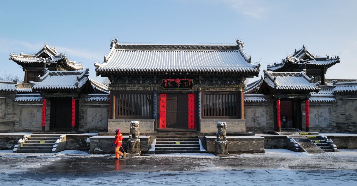 Liaoyang Travel Guide: Ancient Stones, Quiet Streets, and Northeast China’s Older Soul Snow-covered traditional Chinese temple with a person in winter attire walking by.