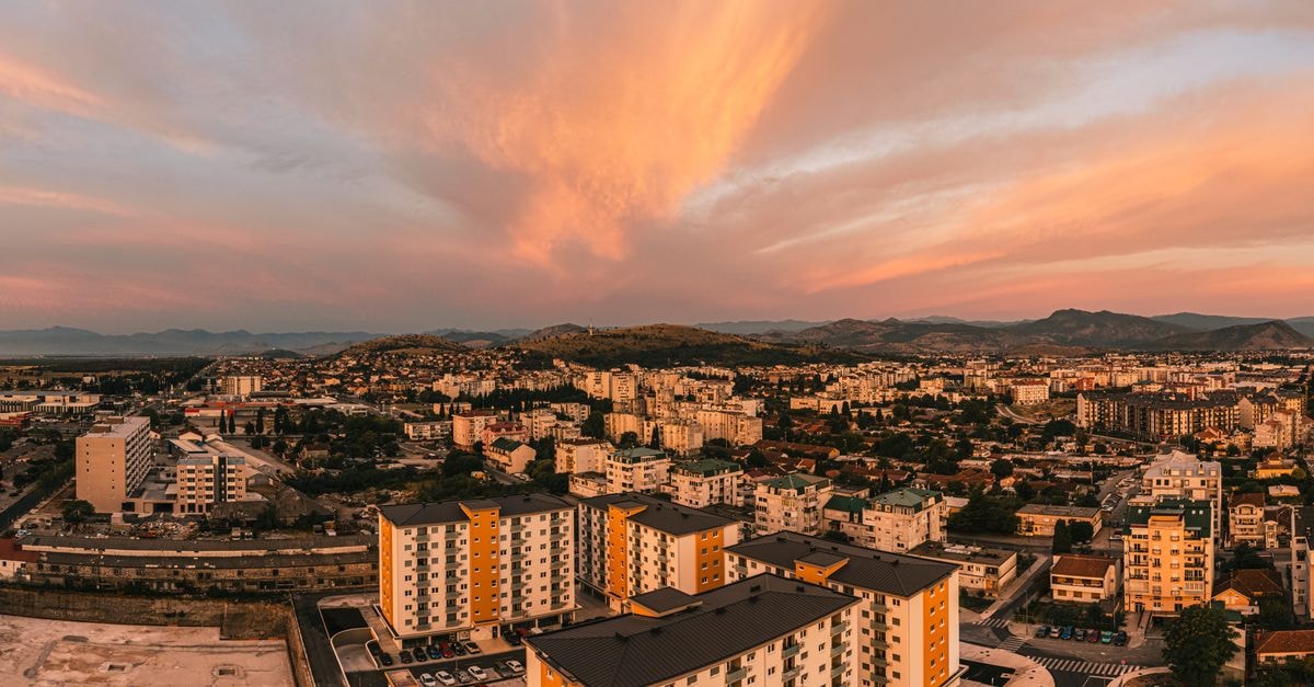 Hotel Gjallica in Kukës: A Renovated Stay on the City Boulevard Scenic aerial view of Podgorica, Montenegro at sunset featuring vibrant skies and urban architecture.