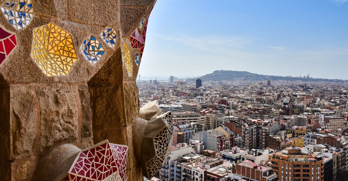 View from a mosaic tower overlooking the vibrant cityscape of Barcelona, capturing architectural beauty and urban life.