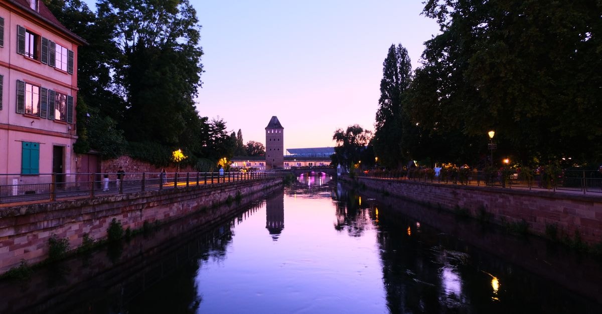 A picturesque sunset view of a canal with historical architecture in Strasbourg, France.