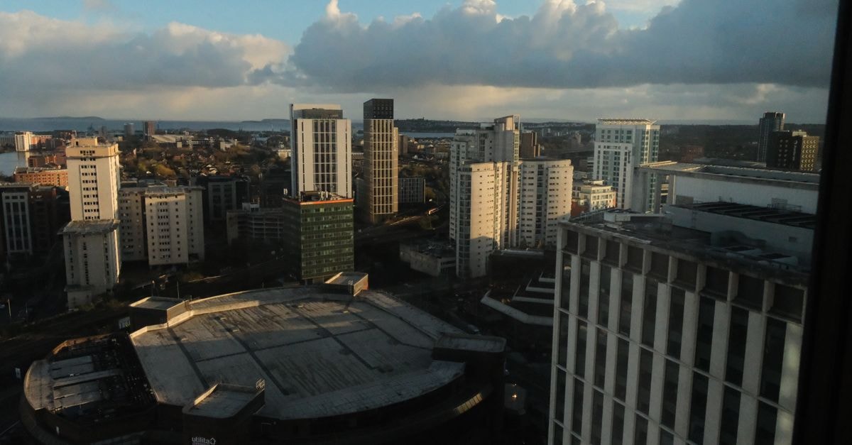 Skyline view of a city with high-rise buildings under clouds captured during the day.