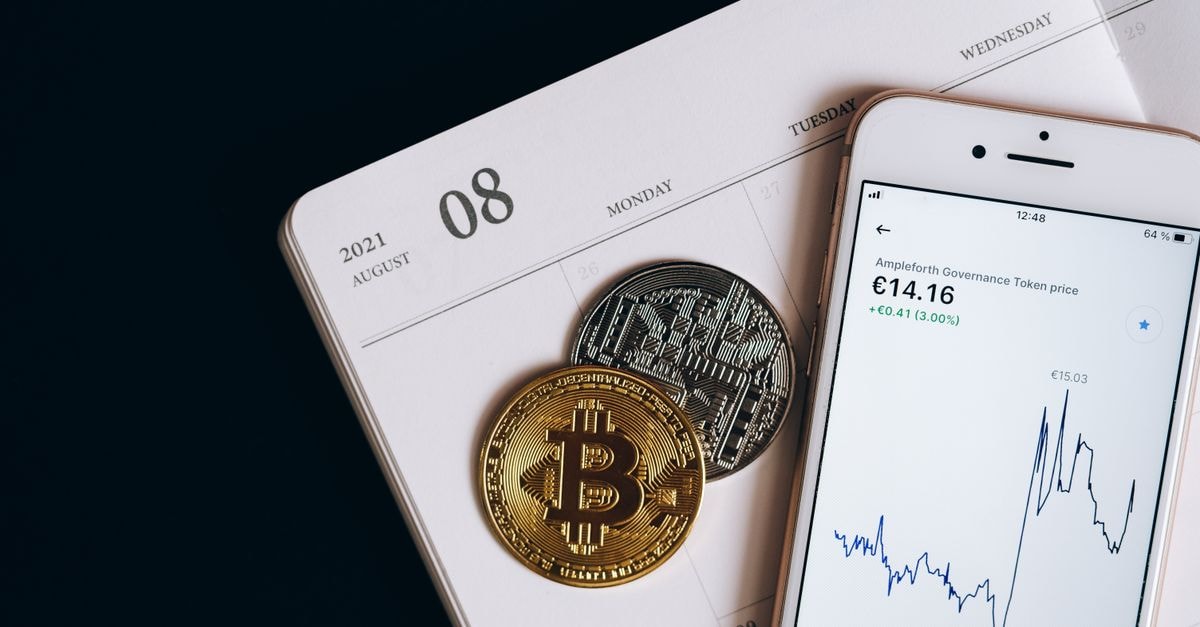 A smartphone displays cryptocurrency data alongside Bitcoin and Ethereum coins on an August calendar.
