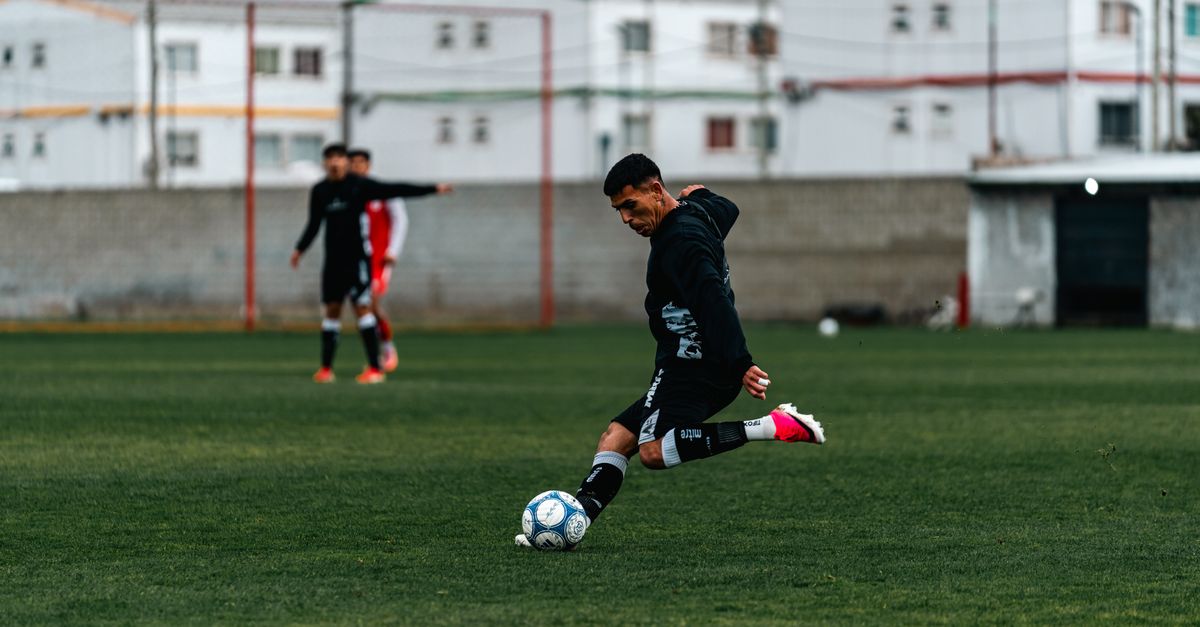 Spider-Man: Brand New Day Pre-Sales Hit $7.1M in China as Domestic Hits 'Dear You' and 'Kung Fu Soccer' Continue to Lead the Market Athlete striking soccer ball during an outdoor match on grass field.