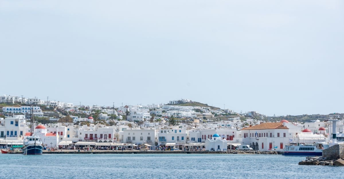 Bluetopia Suites, Mykonos: Cycladic Calm Above the Aegean Serene coastal scene of Mykonos with traditional Greek architecture and blue sea.