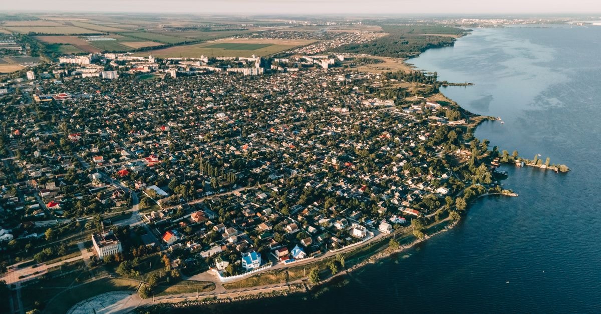 Nadiia Hotel in Ivano-Frankivsk: A Carpathian Gateway Aerial view of a sprawling coastal city with houses, roads, and waterways under clear skies.
