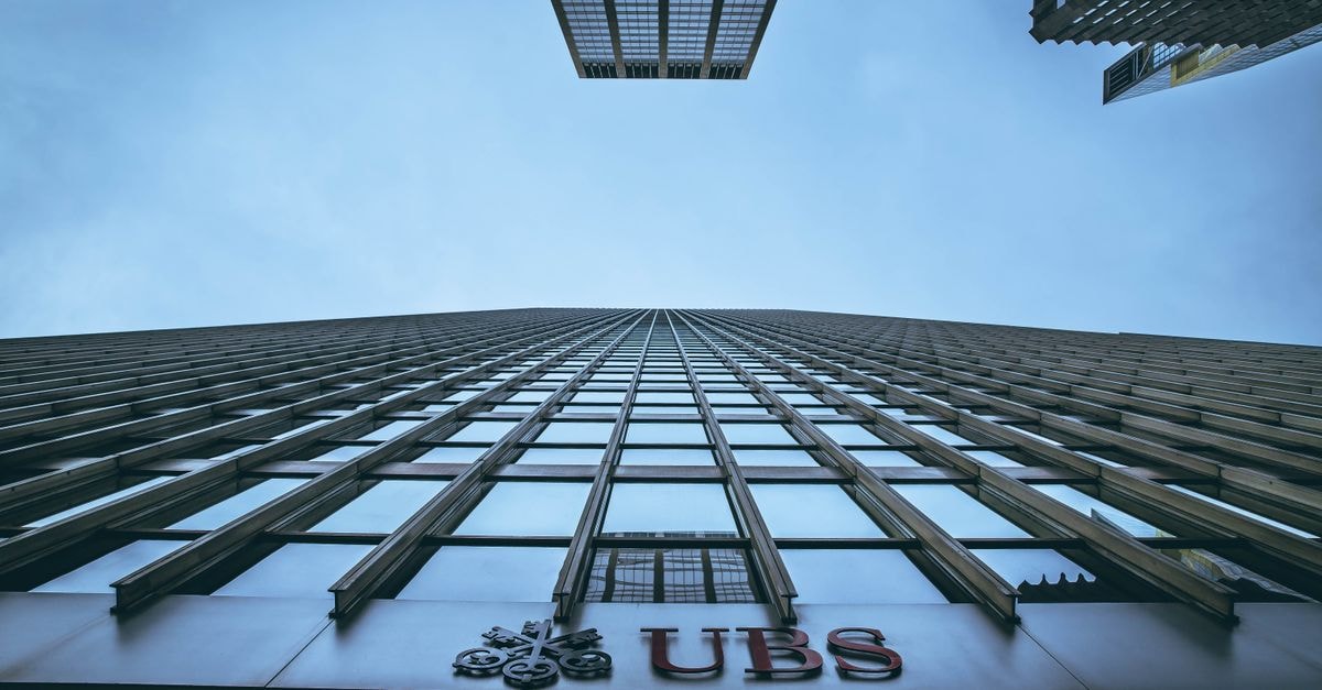 UBS:中國 EUV 微影技術落後 ASML 約十年,停滯於約 2004 年成熟度 仰角拍攝的紐約摩天大樓與 UBS 標誌,強調高度與都市建築風格。
