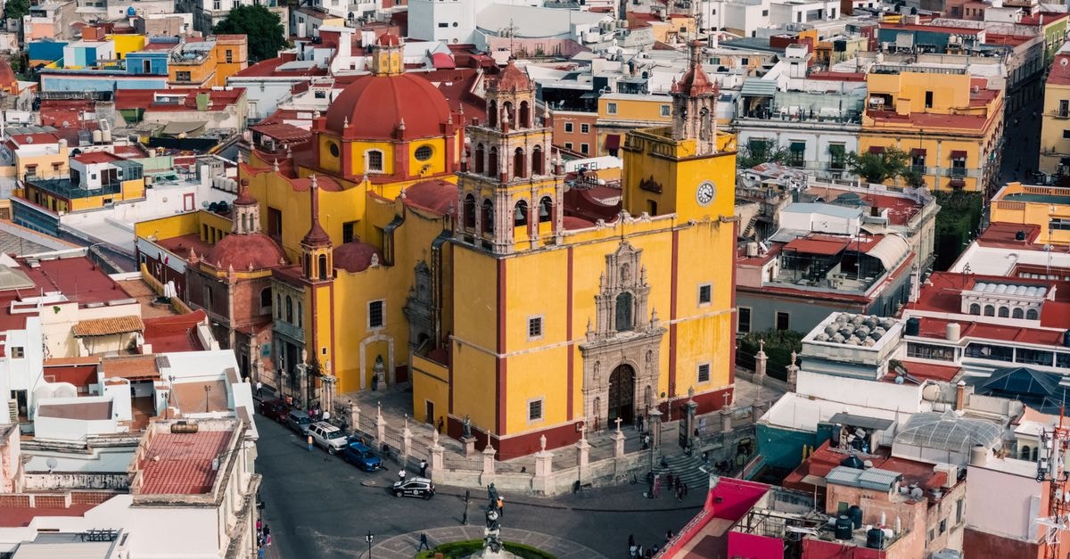 A colorful aerial view of the historic cityscape of Guanajuato featuring notable architecture.