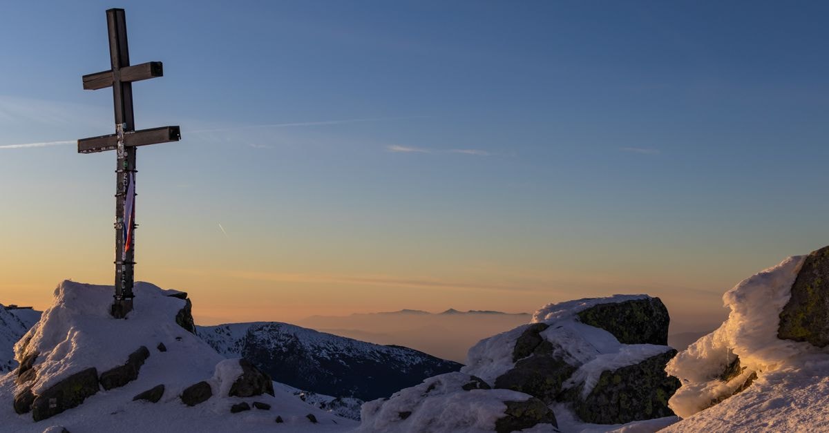 Žilina Travel Guide: A Quiet Slovak City Worth Slowing Down For A serene winter mountain scene with a cross and sunrise sky in Slovakia.