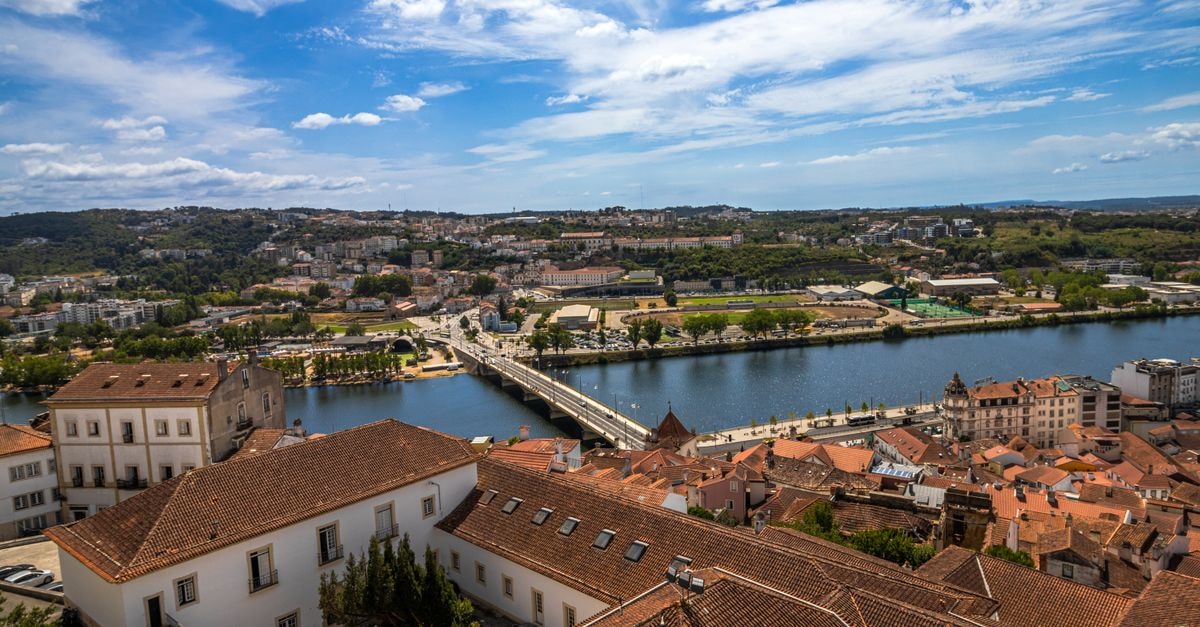 Hotel Miracorgo in Vila Real: River and Mountain Views Aerial view of Coimbra, Portugal, showcasing the Mondego River and historic architecture under a blue sky.