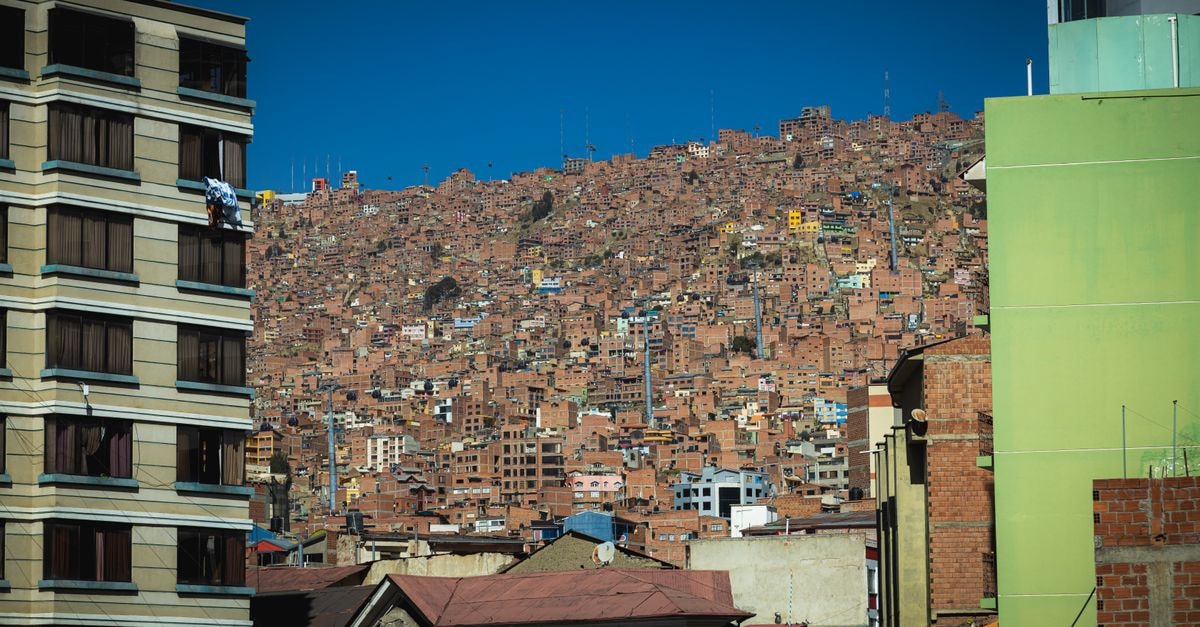 La Paz Travel Guide: Planning Tips, Costs and Things to Do A vibrant view of densely packed hillside houses in La Paz, showcasing urban architecture.