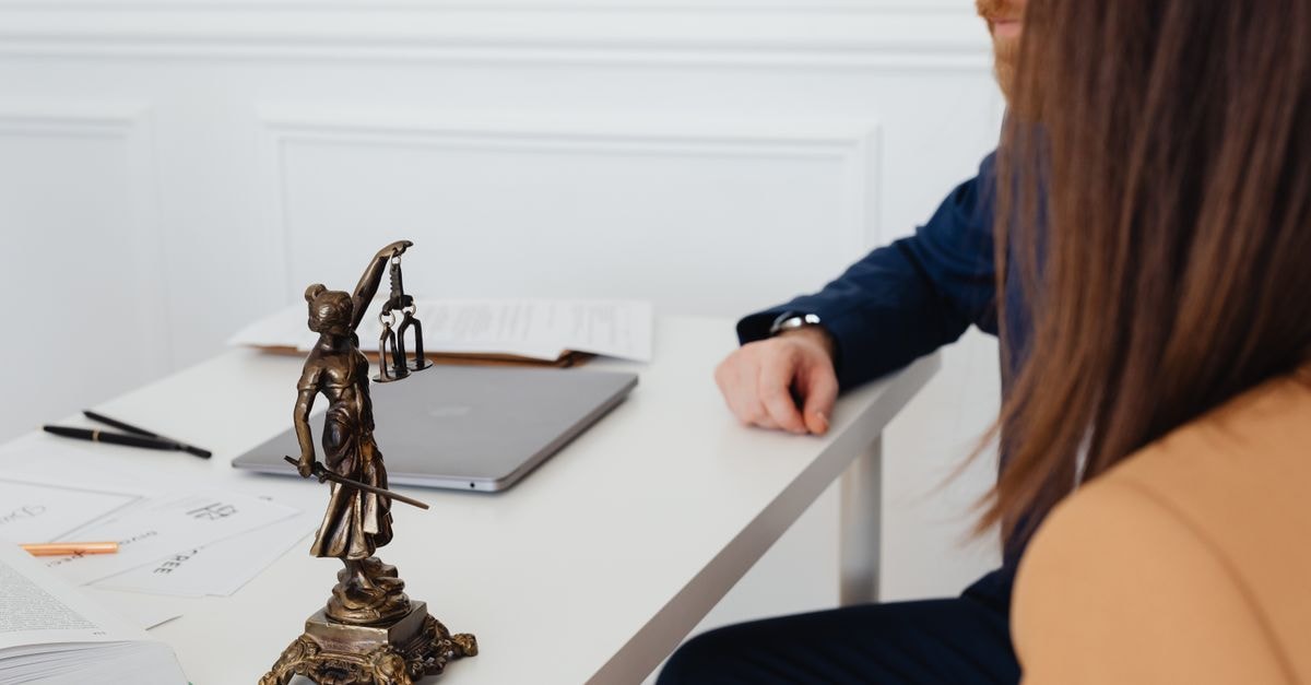 Karnataka suspends food licences of Amazon, Swiggy Instamart and BigBasket over toxic datura sales Professional setting with lawyers and Lady Justice statue discussing legal documents.