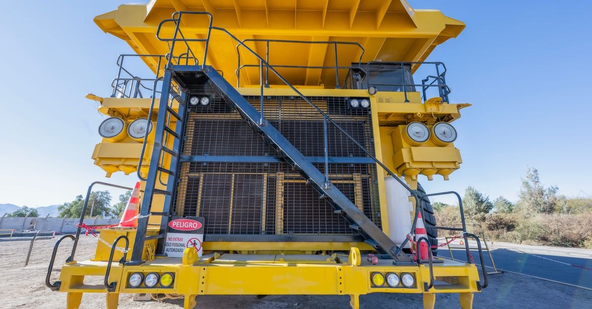 Front view of a large yellow mining truck in Chuquicamata mine, Calama, Chile, on a sunny day.