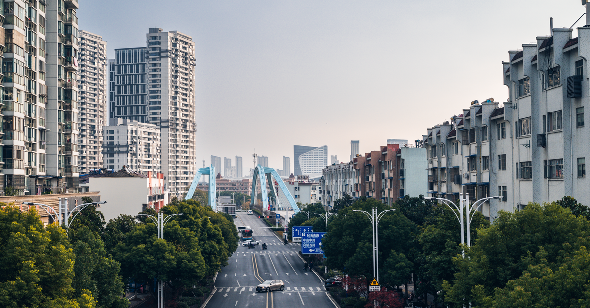 A Slow Travel Guide to Hefei, Anhui's Calm Capital A vibrant city scene in Xuancheng, Anhui, featuring a prominent blue bridge amidst tall buildings.