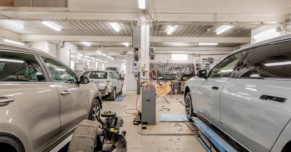 汽車維修廠內部，多輛汽車正在進行保養與維修。