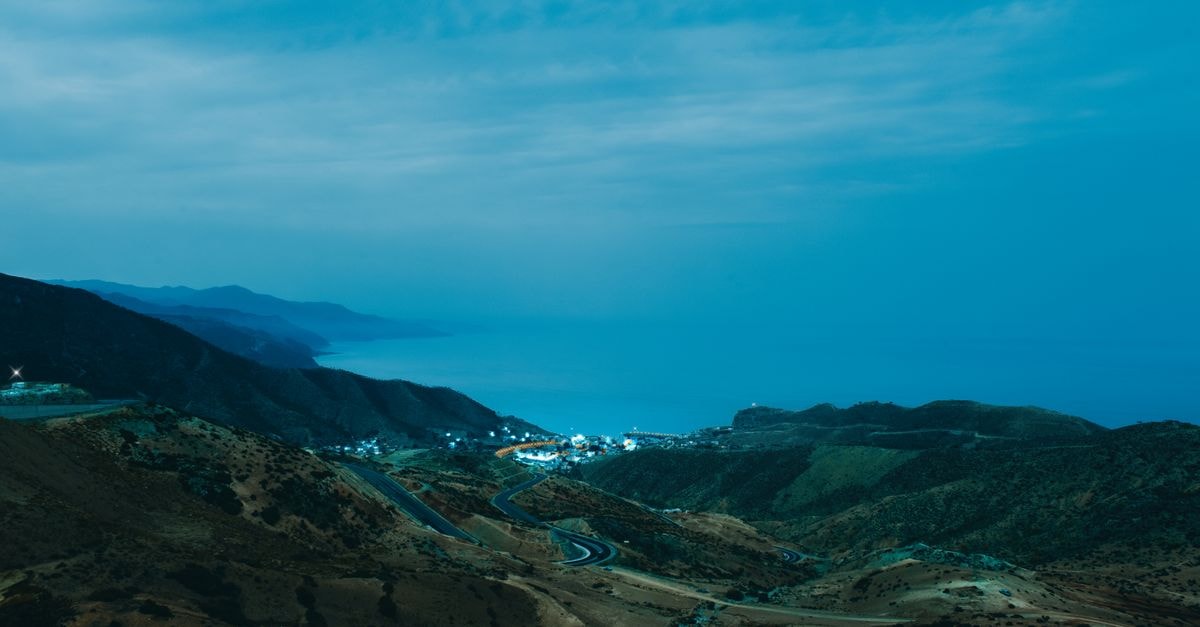 Az Zawiyah Travel Guide: A Quiet Coastal City Worth Discovering A breathtaking coastal landscape of El Jebha, Morocco, at dusk featuring winding roads and serene ocean views.