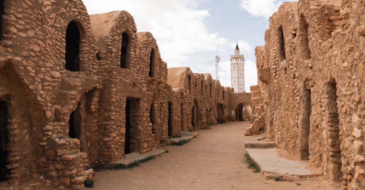 Siliana Travel Guide: Quiet Heritage in Tunisia's Inland North Historic stone granaries with mosque tower in the background, showcasing Tunisia's ancient architecture.