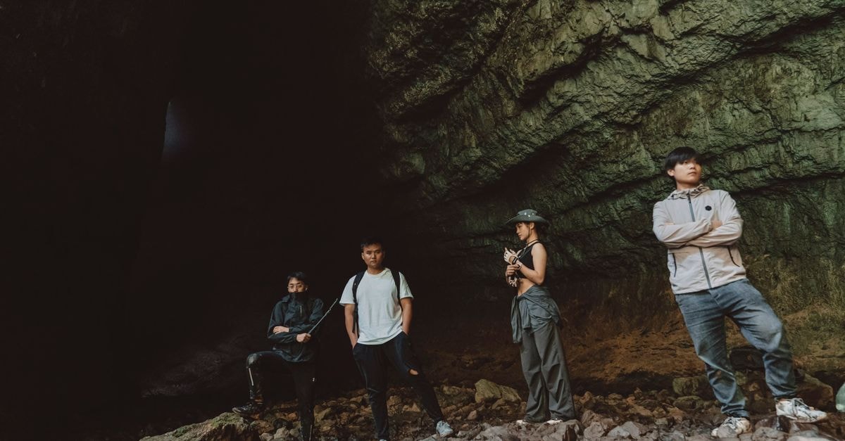 Hanzhong Travel Guide: Mountains, Heritage and a Quieter Side of Shaanxi A group of young adults explore a vast cave in Hanzhong, Shaanxi, China, capturing the spirit of adventure.