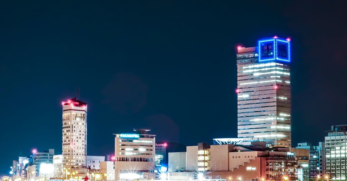 Takamatsu Travel Guide: Gardens, Art, and Sea-to-Table Flavor A vibrant night view of Takamatsu's cityscape in Kagawa, Japan, showcasing illuminated skyscrapers along the waterfront.