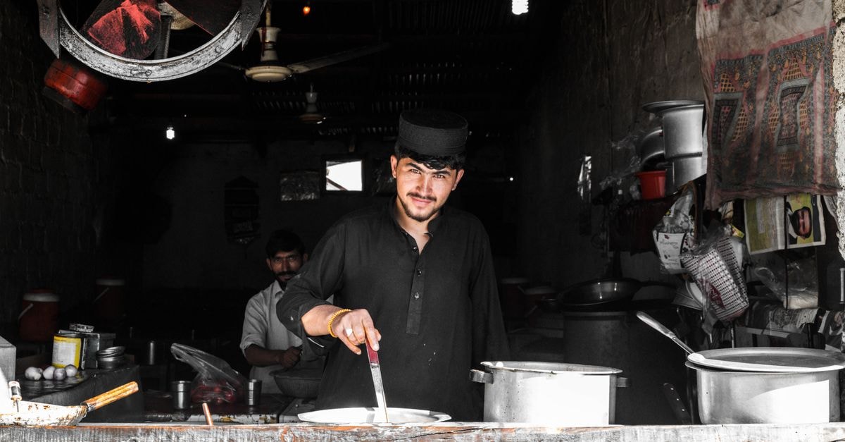 A man cooking in a traditional restaurant setting, showcasing cultural ambiance and culinary skills.