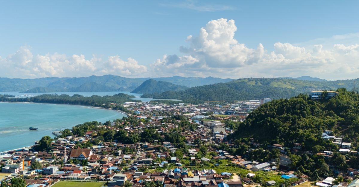 Novotel Lampung in Bandar Lampung: Teluk Lampung Vistas and 220 Rooms Stunning aerial view of Jayapura's coastal landscape with mountains and city below.