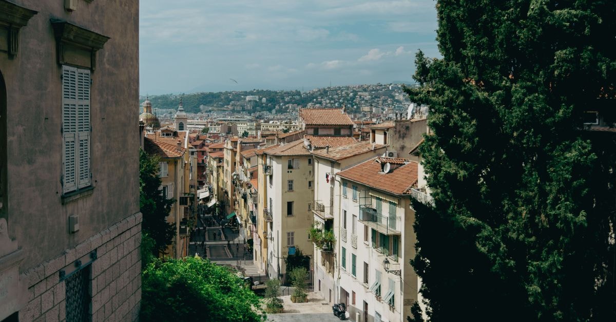 Explore the picturesque streets of Nice with historic architecture and stunning hillside views.