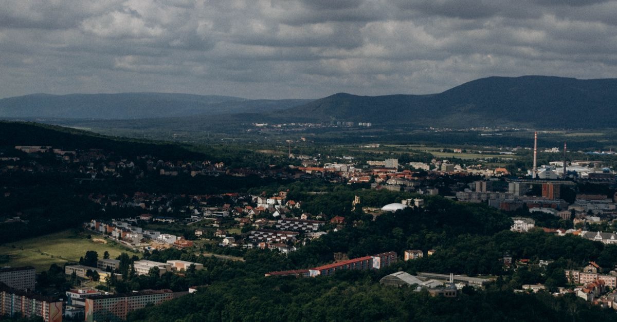 Boutique Hotel Dubná Skala in Žilina: A Secession Story Reborn Panoramic aerial view of a town nestled in a valley with mountain backdrop.