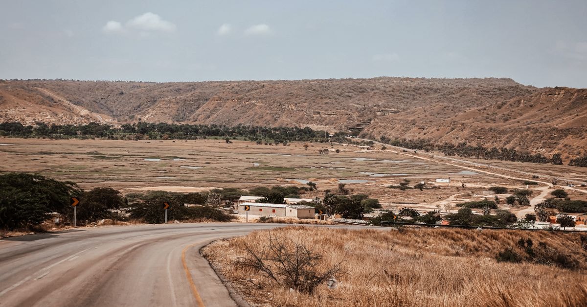 Explore the arid landscapes of Angola featuring winding roads and hill views.
