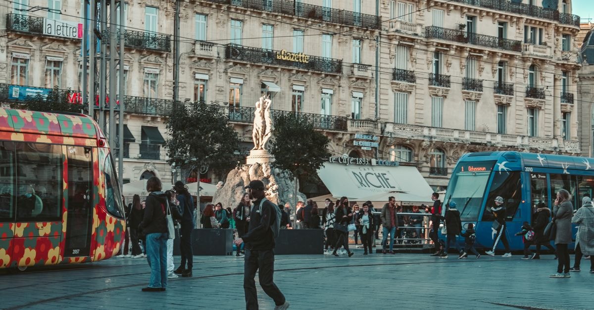 Vibrant street view in Montpellier with colorful trams and classic architecture.