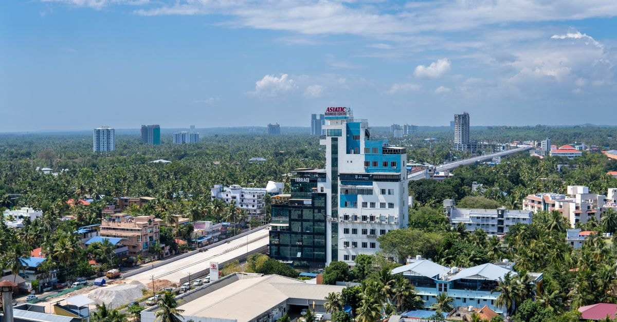 Saas Residency in Kozhikode: City-View Stay Near Kozhikode Beach Panoramic aerial view of Thiruvananthapuram cityscape with lush greenery and modern architecture.