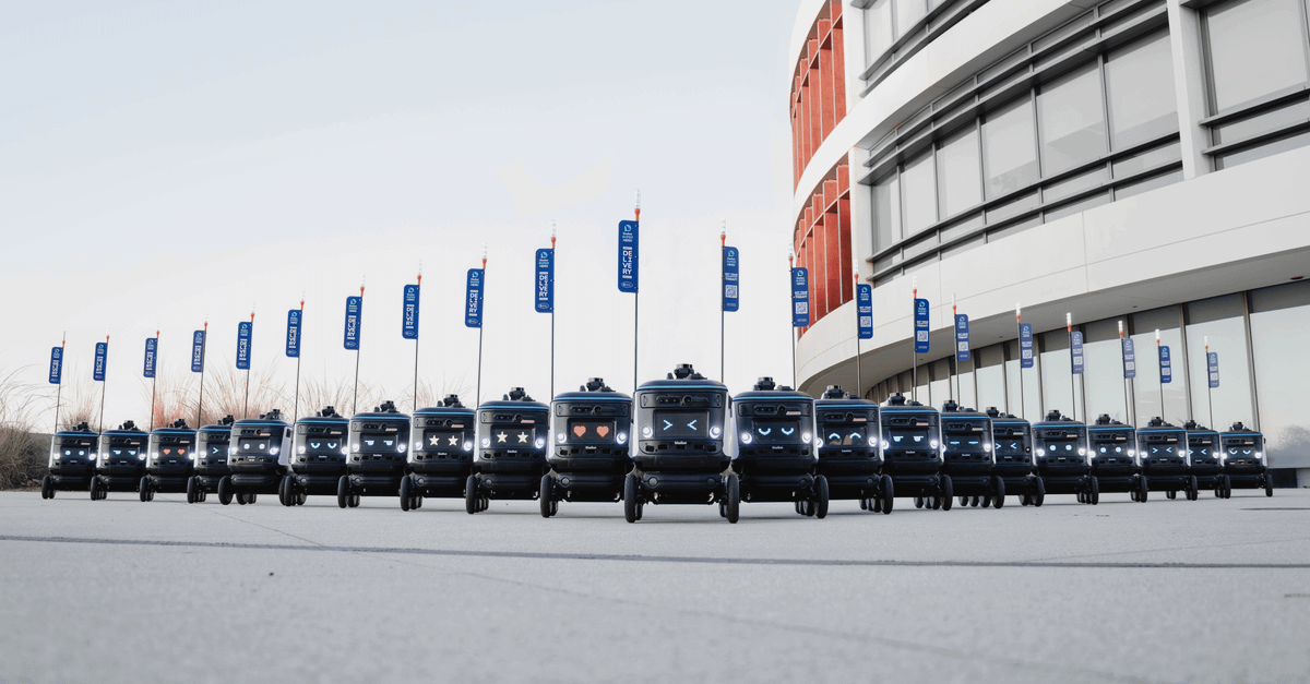 Uber exits Serve Robotics with surprise full stake sale A fleet of delivery robots aligned outside a modern building, illustrating futuristic technology.