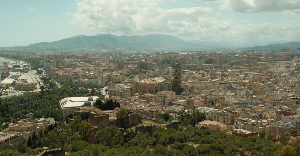 Malaga Travel Guide: Planning Tips, Costs and Things to Do A breathtaking aerial view of Málaga, Spain, showcasing the city's historic architecture and surrounding landscape.