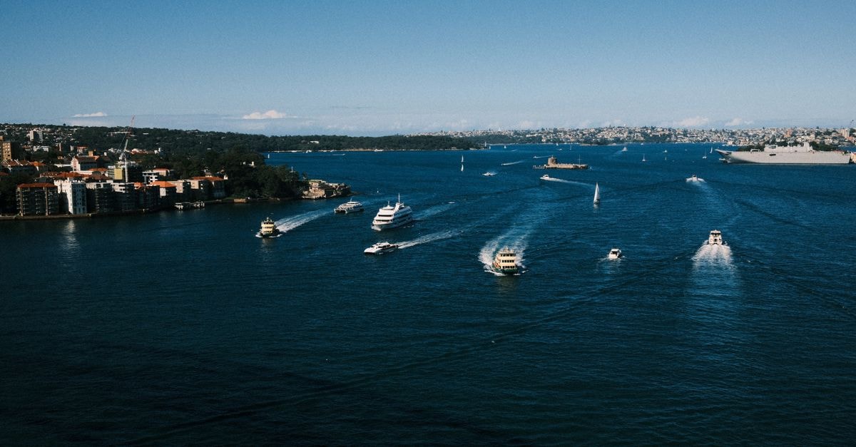 Sydney travel guide: a calm, harbour-side way into the city A stunning view of Sydney Harbour with boats sailing on a bright day, showcasing Sydney's vibrant cityscape and natural beauty.