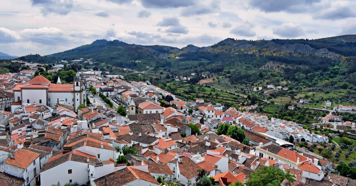 Hotel Bejense in Beja: A Historic-Centre Icon Since 2010 Aerial view of Marvão's charming white houses and red roofs against a mountainous backdrop in Portugal.