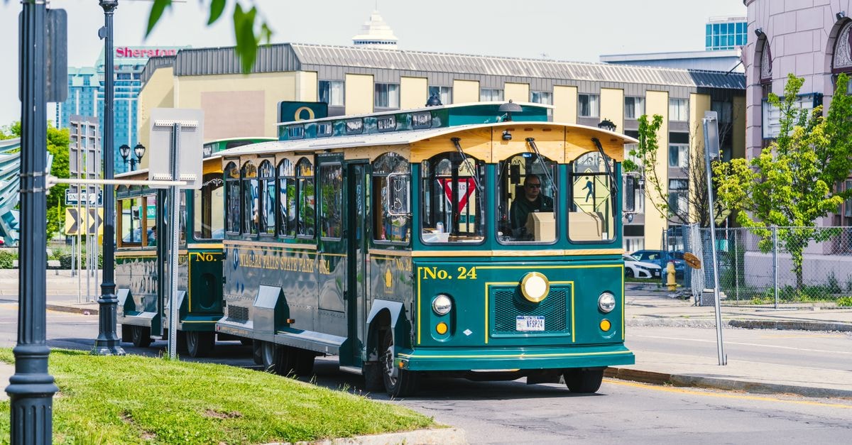 Green trolley bus at Niagara Falls State Park in summer, ideal for sightseeing and tourism.