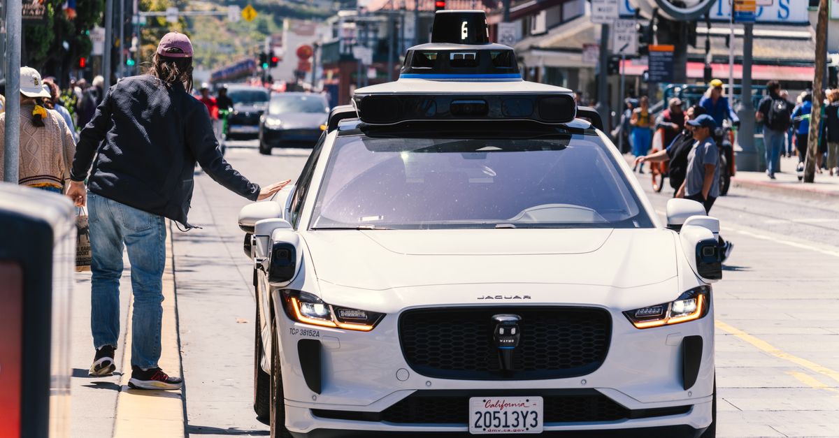 IIHS Report Finds Waymo Robotaxis Involved in 68% Fewer Crashes Than Human Drivers A self-driving car navigates through a bustling city street in San Francisco, capturing urban mobility in action.
